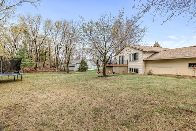 view of yard with a trampoline and a deck