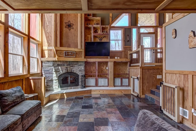 546 315th St, Cady Twp, WI 54749 - living area featuring stone tile floors, a fireplace, and a wainscoted wall