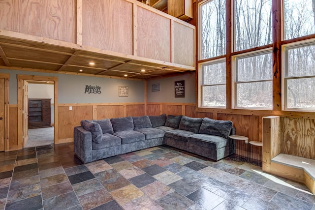 546 315th St, Cady Twp, WI 54749 - living room with stone tile floors, wooden walls, wainscoting, and plenty of natural light