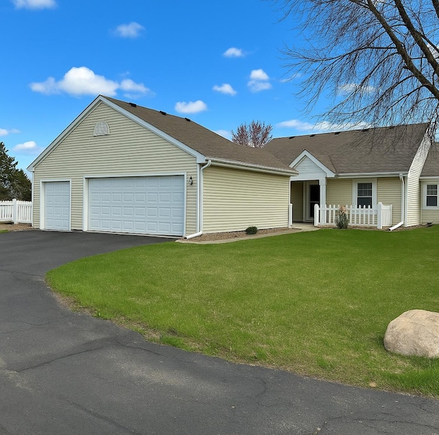 ranch-style home with fence, a garage, and a front yard