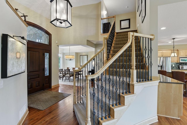 7250 Jubert Ln, Corcoran, MN 55340 - entrance foyer with wood finished floors, stairs, baseboards, a high ceiling, and recessed lighting