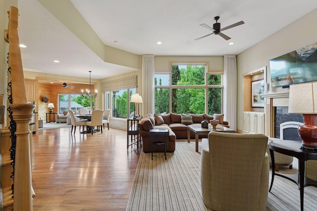 7250 Jubert Ln, Corcoran, MN 55340 - living room with wood finished floors, a premium fireplace, a ceiling fan, recessed lighting, and a chandelier