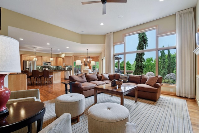 7250 Jubert Ln, Corcoran, MN 55340 - living room featuring recessed lighting, light wood-style flooring, a chandelier, and ceiling fan
