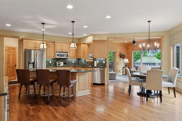 7250 Jubert Ln, Corcoran, MN 55340 - kitchen with stainless steel appliances, a chandelier, a center island, wood finished floors, and recessed lighting