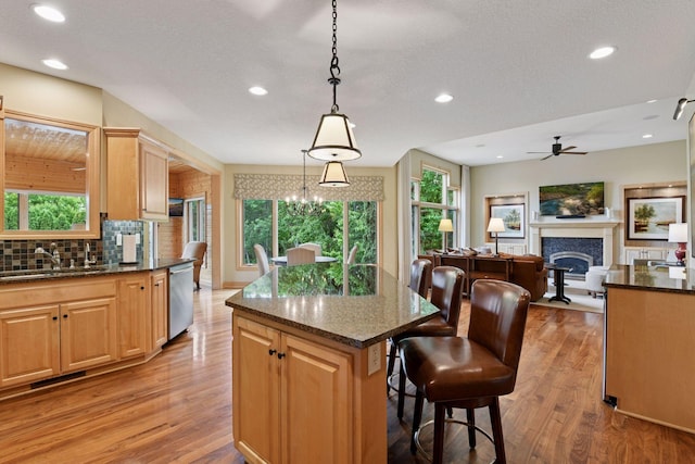 7250 Jubert Ln, Corcoran, MN 55340 - kitchen with a sink, dishwasher, ceiling fan, a fireplace, and light wood-type flooring