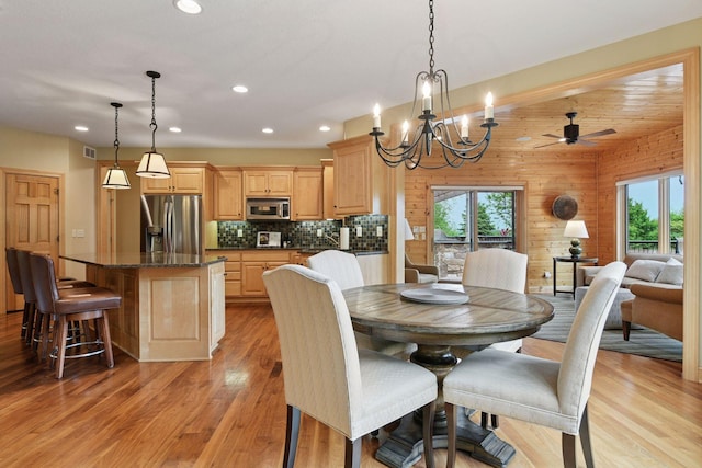 7250 Jubert Ln, Corcoran, MN 55340 - dining room with a chandelier, light wood-style flooring, recessed lighting, ceiling fan, and wood walls