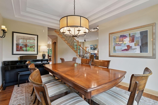 7250 Jubert Ln, Corcoran, MN 55340 - dining room with stairs, a chandelier, wood finished floors, baseboards, and a tray ceiling
