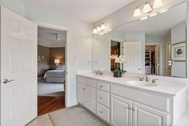 7250 Jubert Ln, Corcoran, MN 55340 - ensuite bathroom featuring double vanity, a spacious closet, tile patterned floors, and baseboards
