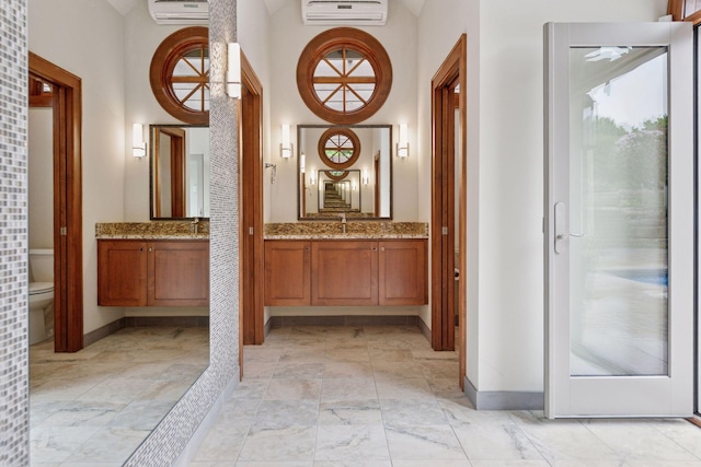 7250 Jubert Ln, Corcoran, MN 55340 - bathroom with marble look tile flooring, a wall mounted AC, baseboards, vanity, and a towering ceiling