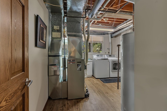 utility room with independent washer and dryer, gas water heater, and heating unit