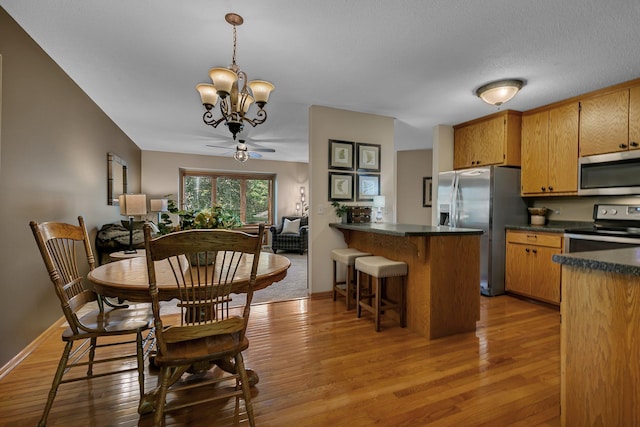 1410 4th Ave N, Sartell, MN 56377 - dining space with a chandelier, light wood-type flooring, ceiling fan, and baseboards