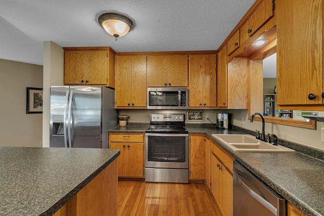 1410 4th Ave N, Sartell, MN 56377 - kitchen featuring stainless steel appliances, a sink, dark countertops, and a textured ceiling