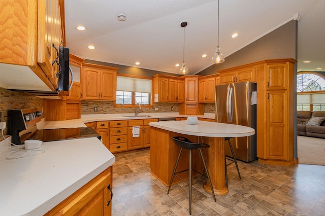 235 Morning View Rd, Sauk Centre, MN 56378 - kitchen featuring appliances with stainless steel finishes, a sink, a breakfast bar area, backsplash, and vaulted ceiling