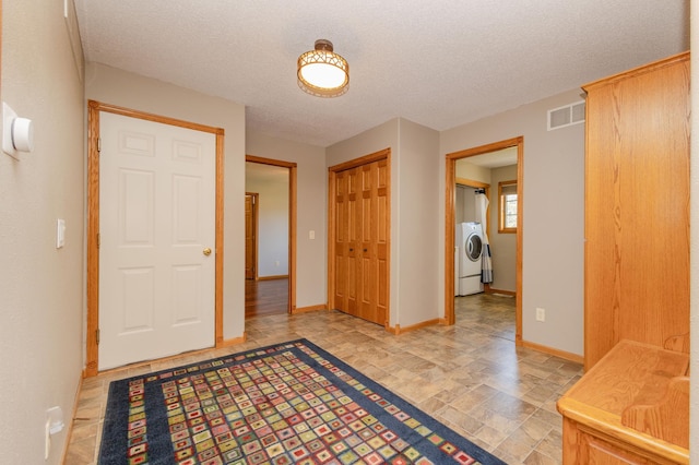 235 Morning View Rd, Sauk Centre, MN 56378 - entryway featuring a textured ceiling, visible vents, baseboards, and washer / dryer