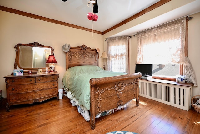 265 Broadway St, Winona, MN 55987 - bedroom with radiator heating unit, hardwood / wood-style floors, a ceiling fan, and crown molding