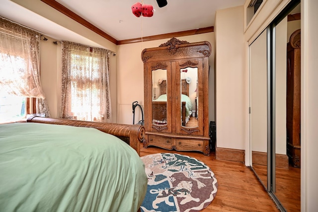 265 Broadway St, Winona, MN 55987 - bedroom featuring wood finished floors, a closet, a ceiling fan, and ornamental molding