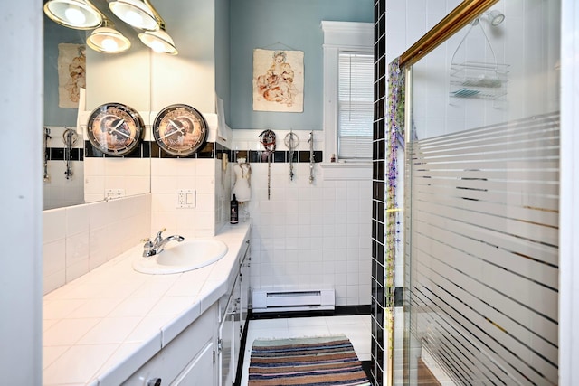 265 Broadway St, Winona, MN 55987 - full bath with a baseboard radiator, vanity, a shower stall, tile walls, and tile patterned floors
