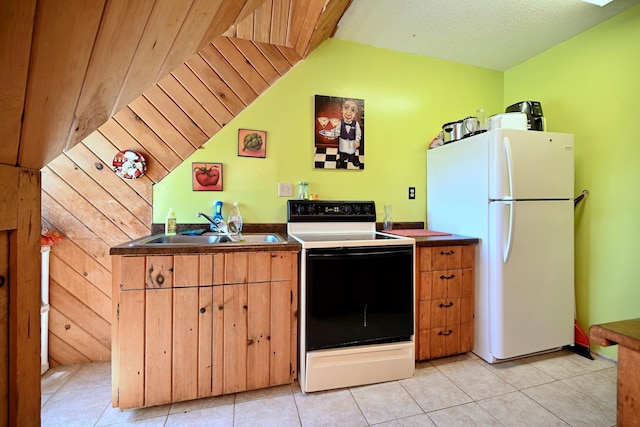 265 Broadway St, Winona, MN 55987 - kitchen with white appliances, lofted ceiling, dark countertops, and light tile patterned flooring