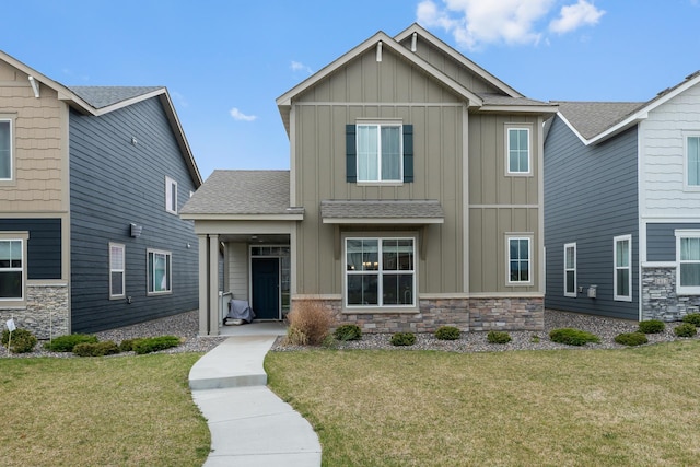 craftsman-style home featuring board and batten siding, a front lawn, and stone siding