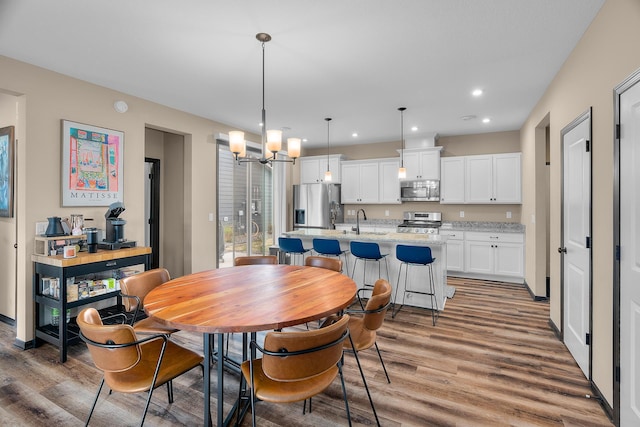 dining space featuring recessed lighting, an inviting chandelier, and light wood finished floors
