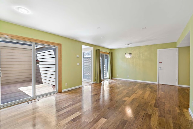 unfurnished living room featuring wood finished floors and baseboards
