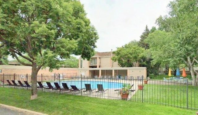 community pool with a yard and fence