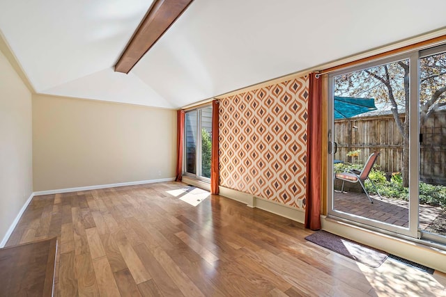 unfurnished living room with baseboards and wood finished floors