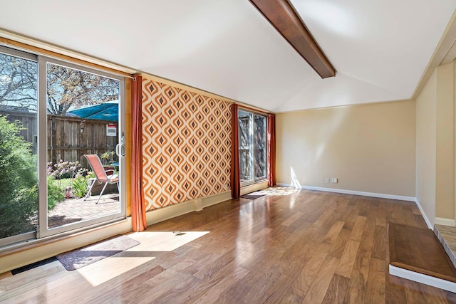 unfurnished living room featuring wood finished floors and baseboards