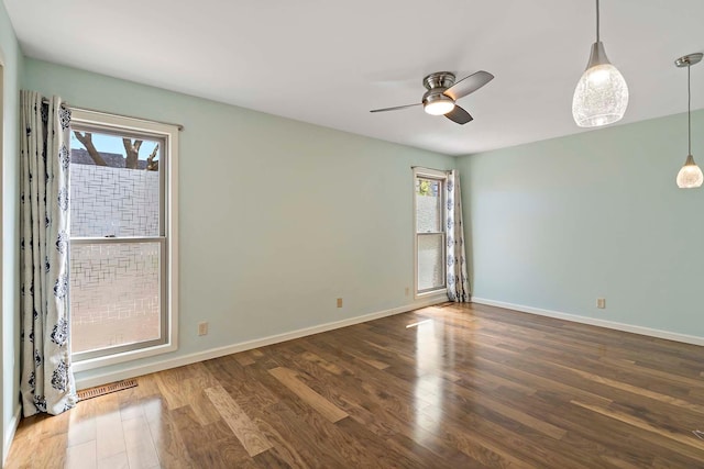unfurnished room featuring wood finished floors, a ceiling fan, and baseboards
