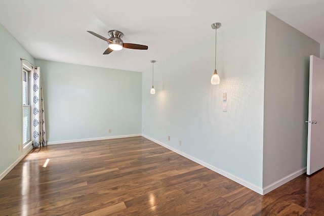 unfurnished room featuring ceiling fan, baseboards, and wood finished floors