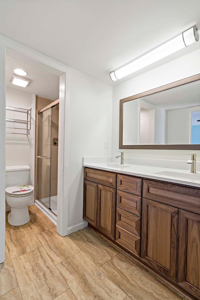 full bath featuring toilet, a shower stall, and double vanity