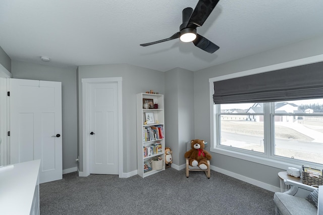 sitting room with baseboards, a ceiling fan, a textured ceiling, and carpet