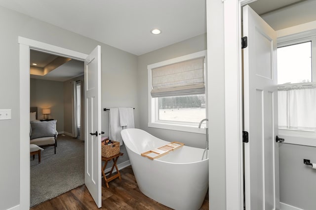 1261 Skyview Cir NW, Rochester, MN 55901 - bathroom featuring wood finished floors, a soaking tub, baseboards, and recessed lighting