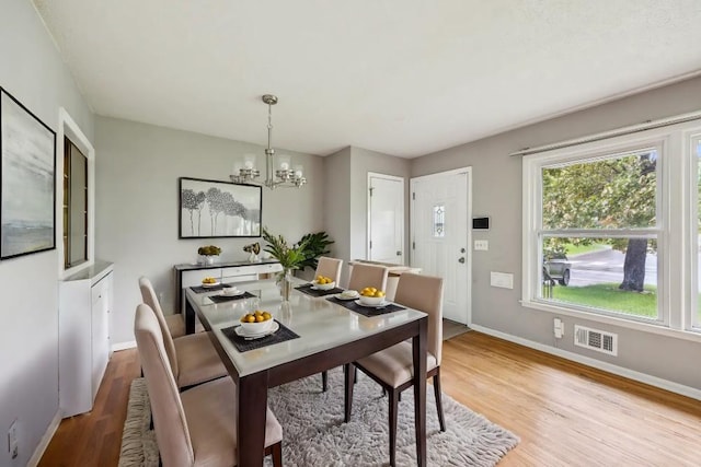 810 57th Ave N, Brooklyn Center, MN 55430 - dining space with a chandelier, wood finished floors, and baseboards