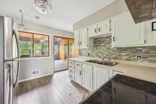 810 57th Ave N, Brooklyn Center, MN 55430 - kitchen with freestanding refrigerator, a sink, baseboards, and decorative backsplash