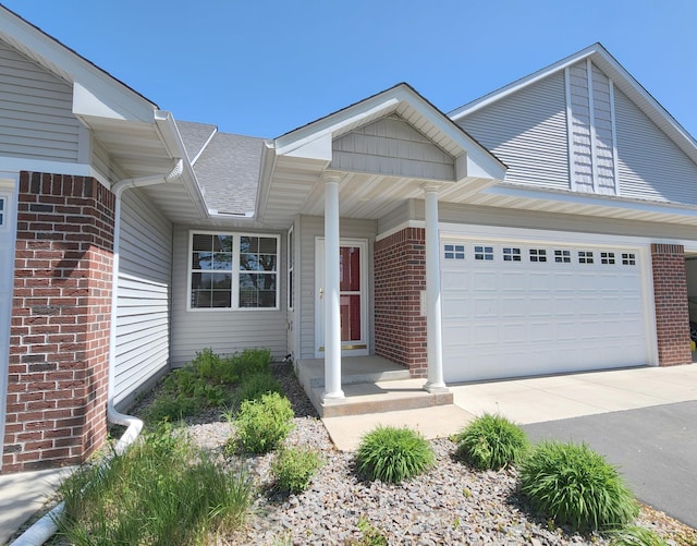 11096 16th St NE, Saint Michael, MN 55376 - view of front of home with brick siding, a garage, driveway, and roof with shingles