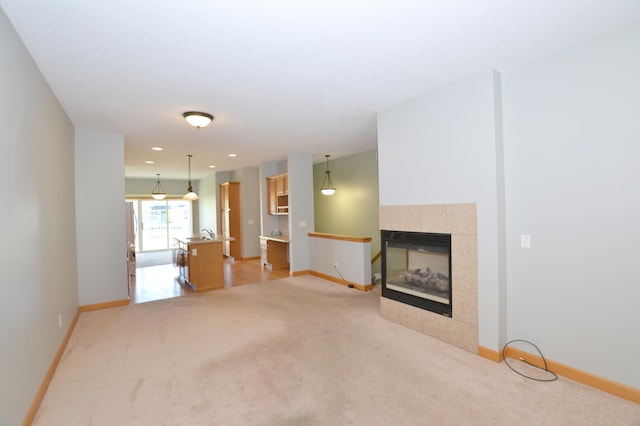 11096 16th St NE, Saint Michael, MN 55376 - unfurnished living room with light carpet, baseboards, a tiled fireplace, and recessed lighting