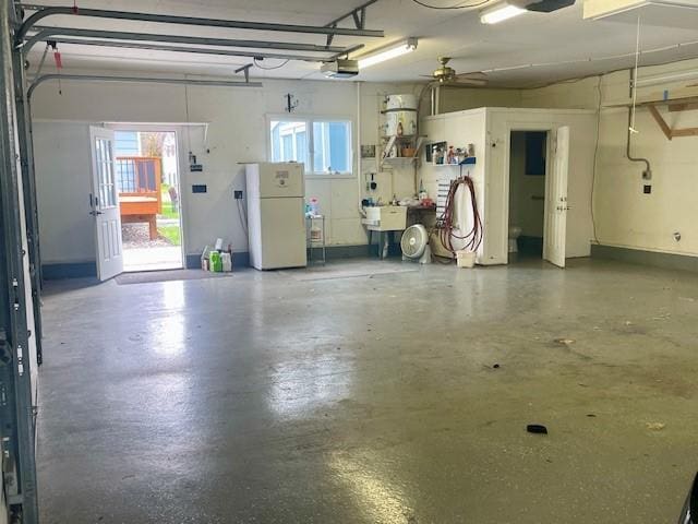 garage featuring freestanding refrigerator, a garage door opener, and a sink