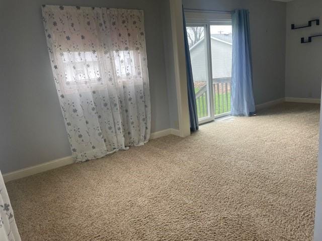 carpeted spare room with baseboards