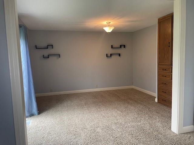 empty room with light colored carpet and baseboards