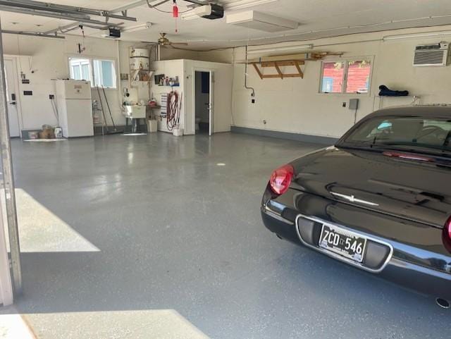 garage featuring freestanding refrigerator, a garage door opener, and a sink