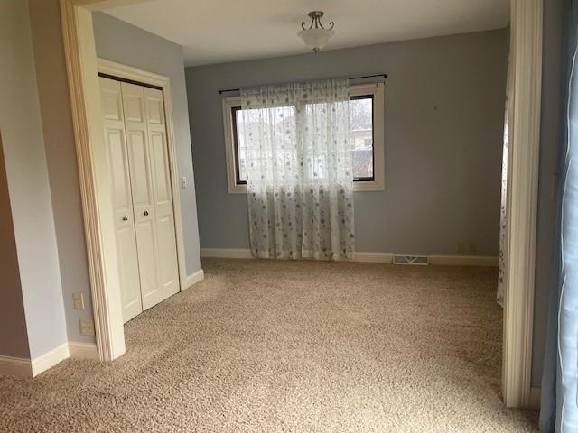 unfurnished bedroom with carpet, a closet, and baseboards