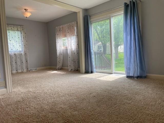 spare room featuring carpet flooring and baseboards