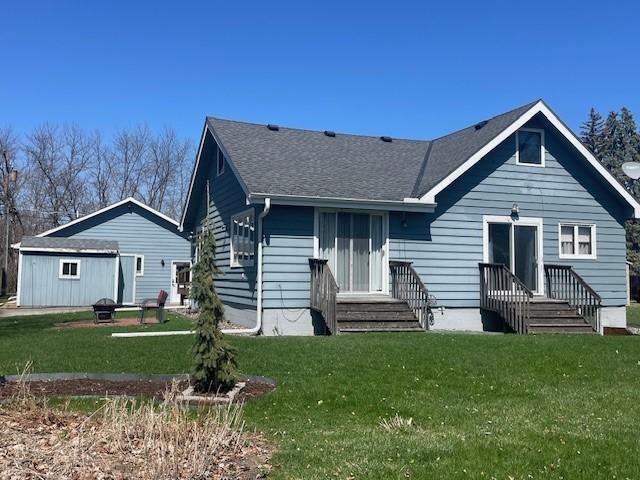 view of front of house with a front lawn and a shingled roof