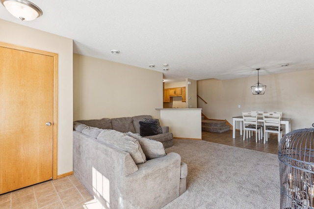 living room featuring baseboards and stairs