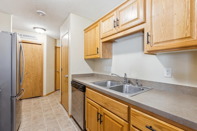 kitchen with a sink, stainless steel appliances, and a textured ceiling