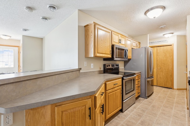 kitchen featuring appliances with stainless steel finishes and a textured ceiling