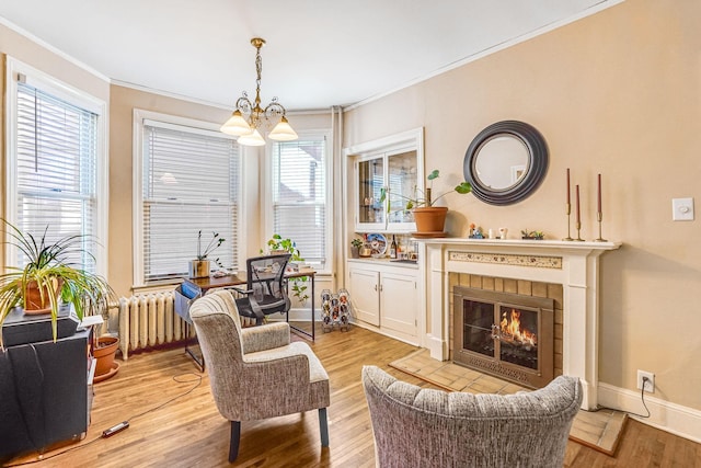 1976 Iglehart Ave, Saint Paul, MN 55104 - living area featuring crown molding, a chandelier, wood finished floors, baseboards, and a tiled fireplace