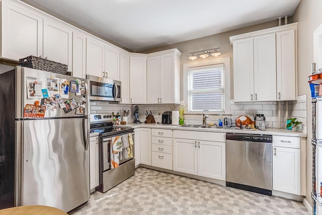 1976 Iglehart Ave, Saint Paul, MN 55104 - kitchen featuring appliances with stainless steel finishes, a sink, light countertops, backsplash, and white cabinetry