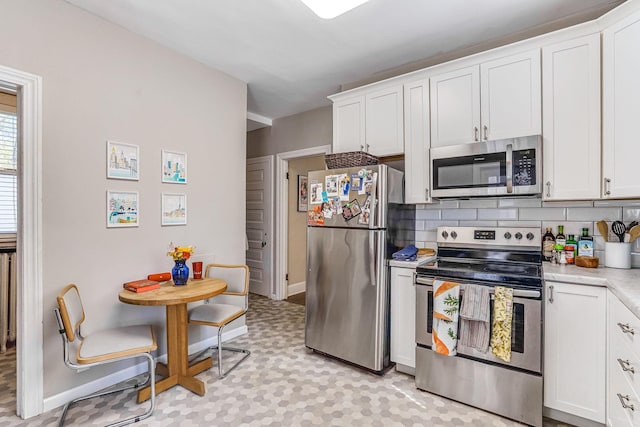 1976 Iglehart Ave, Saint Paul, MN 55104 - kitchen with appliances with stainless steel finishes, light countertops, decorative backsplash, and white cabinets